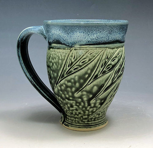 Handmade stoneware mug by Ira Burhans with leaf carving in teal